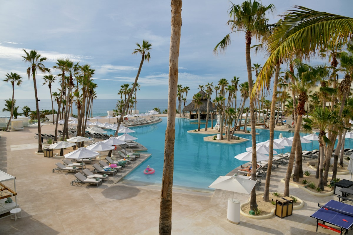 Resort todo incluido con piscina y palmeras frente al mar